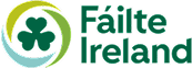 Fáilte Ireland logo featuring a green shamrock inside a circular design with green and blue accents, and the words Fáilte Ireland in green text to the right.
